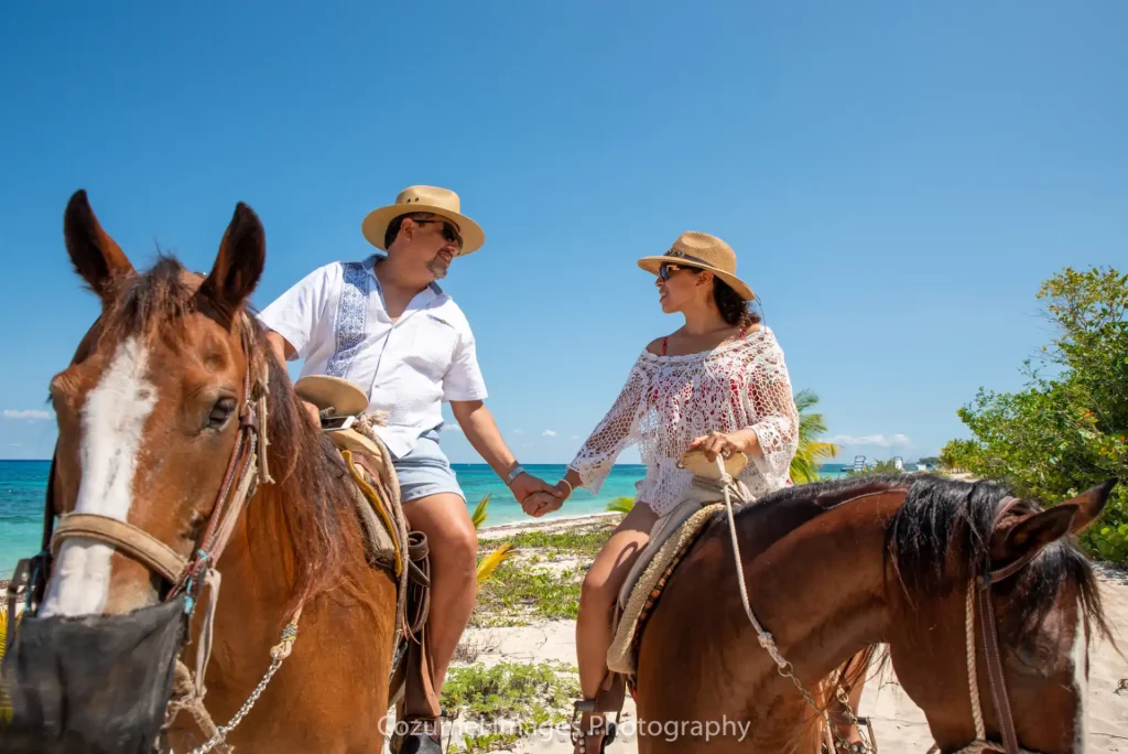 Couple holding hands while horse back riding
